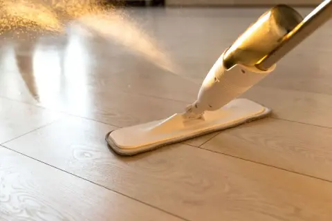 Mop spryskuje wodą jasne panele winylowe. Dowiedz się, czym myć panele winylowe, by lśniły czystością.